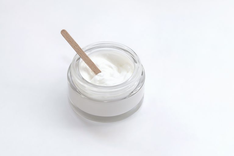 Glass jar with cream and a wooden stick made at home
