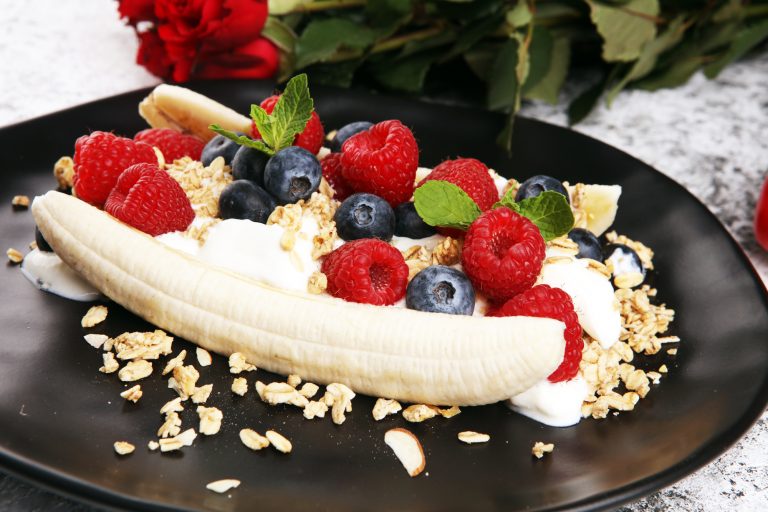 Sweet healthy Homemade Banana Split with yogurt, granola, berries and mint
