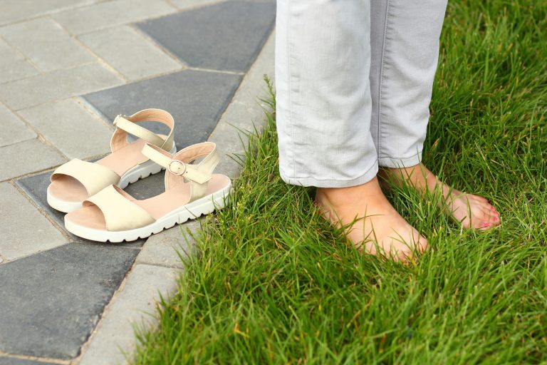 woman grounding herself by putting feet in grass