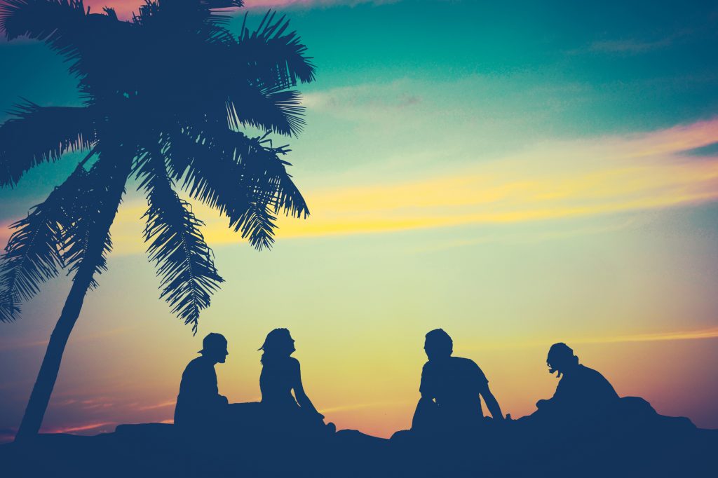 Retro Filtered Image Of Friends By The Beach