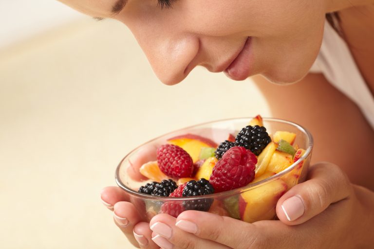 close up of woman consciously looking at bowl of fruit