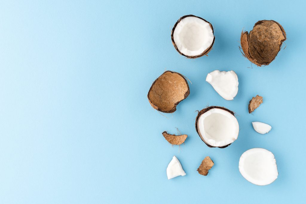 Overhead shot of coconut pieces on blue background.