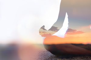 Double exposure of young woman silhouette practicing yoga and meditating